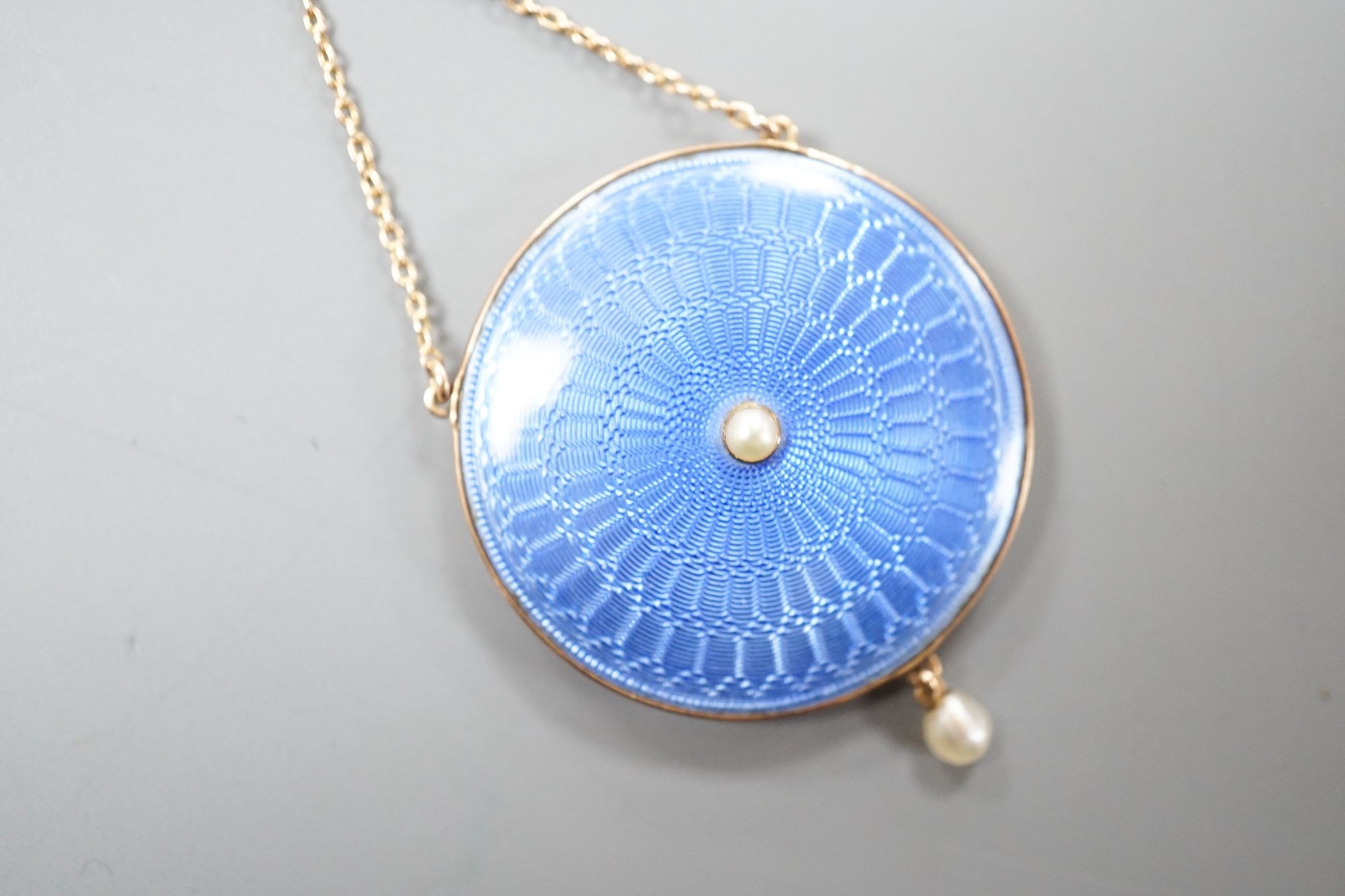 An Edwardian yellow metal, blue guilloche enamel and seed pearl set pendant necklace, pendant, 28mm, overall approx. 48cm, gross 11.3 grams.